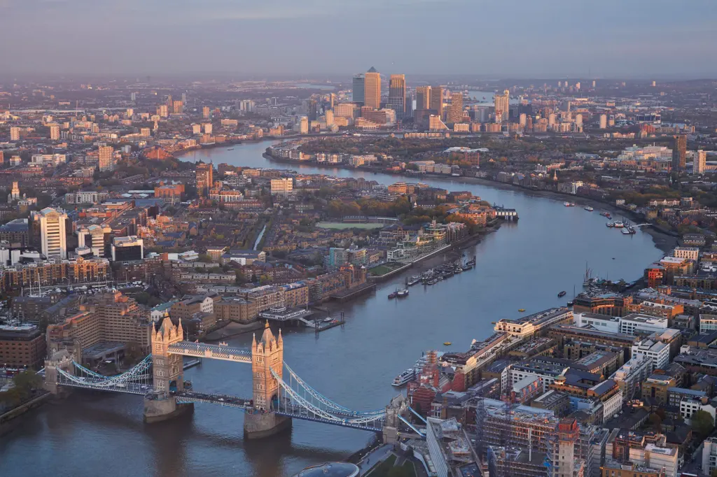Aerial view of Tower Bridge, the Thames and Canary Wharf at dusk.